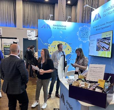 Conference attendees near the Ambitious for Norfolk stand